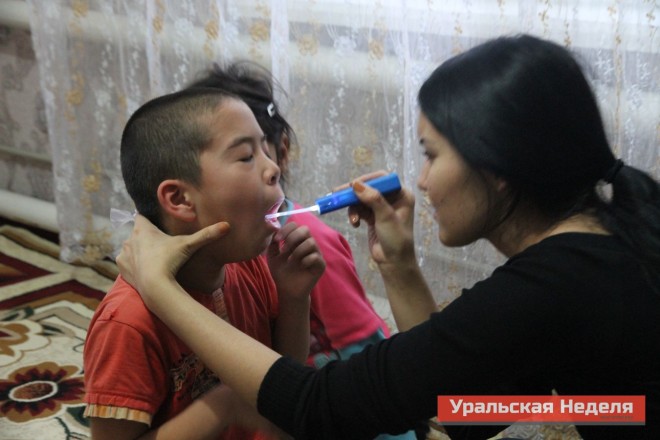 On December 4, the nurses from the central district hospital began to carry out door-to-door inspections of all of the children in the village. This photo shows a nurse examining Rinat Asylbekov, who did not go to school that day because he felt unwell. (Photo courtesy of Uralskaya Nedelya)