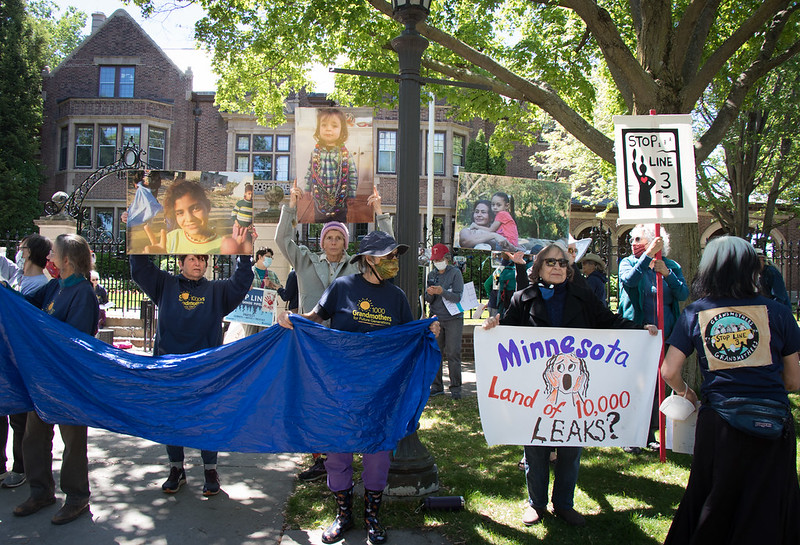 Image shows members of 1000 Grandmothers and Lakota and Ojibwe women holding signs outside of the Governor's mansion.